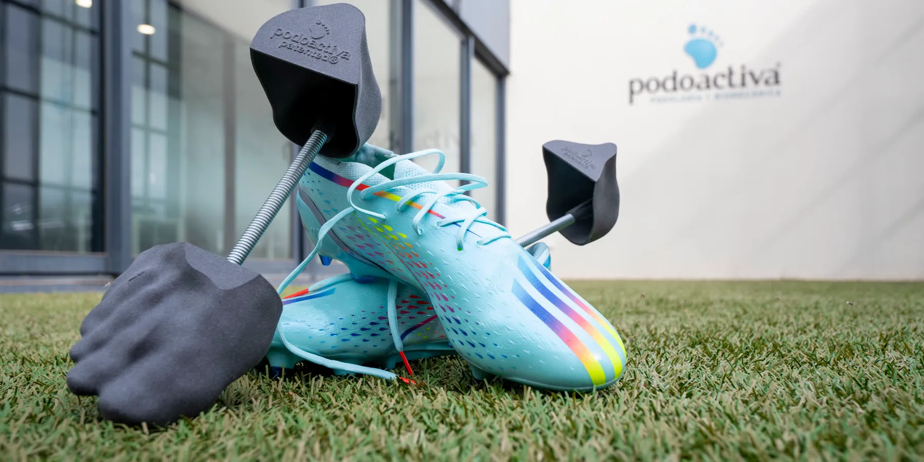 Hormas personalizadas YouNext junto a botas de fútbol sobre césped